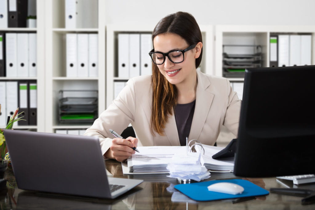 lady working at desk with rows of files