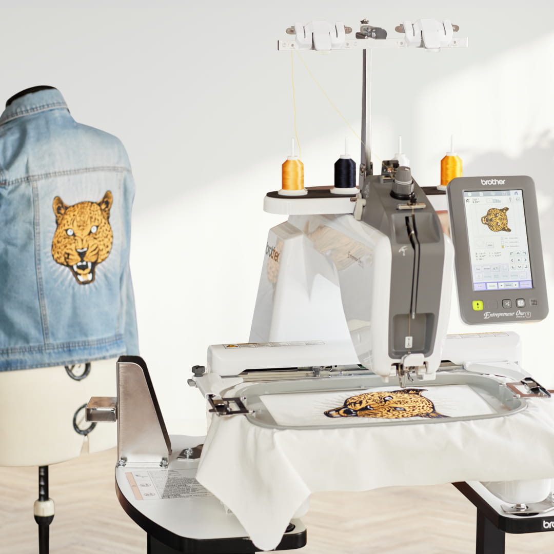 Image of the Brother PR1X embroidering a built-in design of a cheetah on fabric and a completed jacket back with the same design